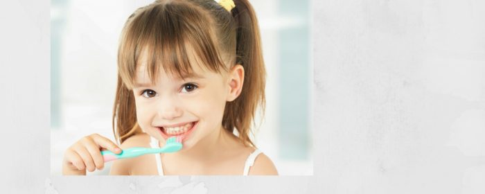 niña con cepillo de dientes