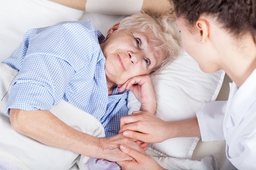 Elderly woman in bed and her nurse