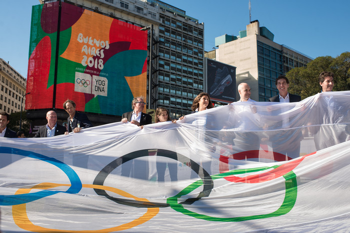 personas con bandera de juegos olímpicos