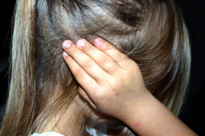 niña tapandose los oidos