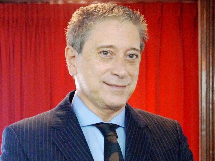 Carlos Felice sobre cortina roja