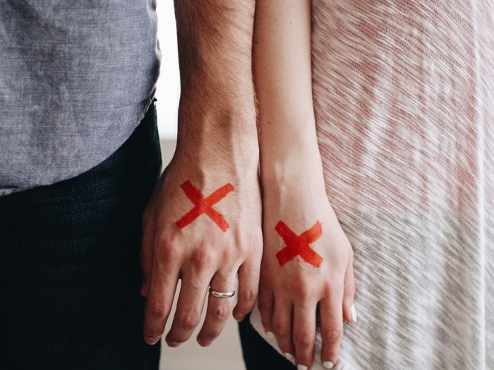 dos manos pintadas con cruces rojas