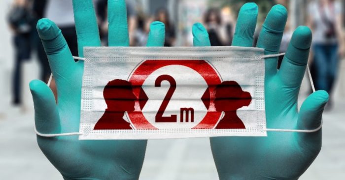 manos con guantes sosteniendo cartel sobre coronavirus