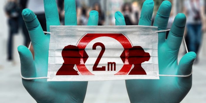 manos con guantes sosteniendo cartel sobre coronavirus