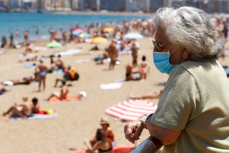 mujer en la playa con barbijo