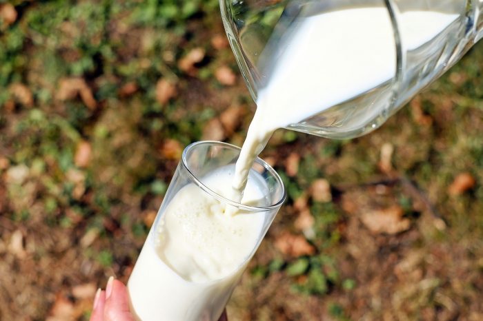 jarra de leche sirviendo en un vaso