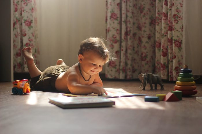 niño jugando en el piso con juguetes