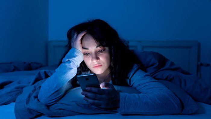 adolescente con celular de noche